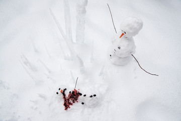 Bloody dead snowman impaled on a sharp icicle during a winter storm
