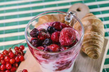 milk yogurt with raspberry jam and frozen strawberries and cherries. fresh vitamin breakfast.