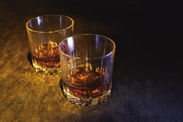 Whiskey in a glass on a dark wooden background.