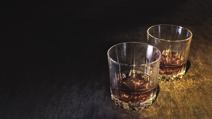 Whiskey in a glass on a dark wooden background.