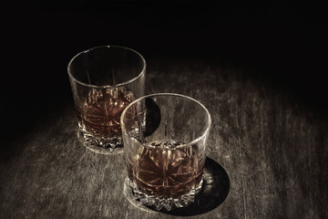 Whiskey in a glass on a dark wooden background.