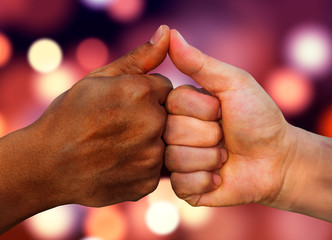 multiracial hands together African American and Caucasian touching thumbs as team in promise sign...