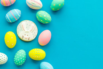 Easter symbols. Colorful Easter eggs and gingerbread on blue background space for text
