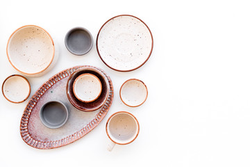 Obraz na płótnie Canvas Ceramic tableware pattern. Empty plates and mugs on white background top view copy space