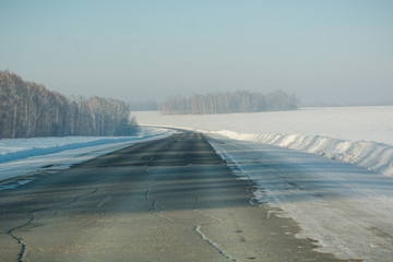 Winter road among the fields. The road among the fields. Snow fields.
