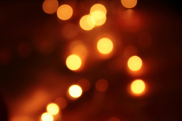 abstract blurred glowing light particles of shades of light gold and red