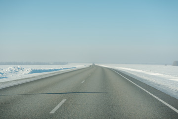 The road in winter. Asphalt road in winter. Road under the snow.