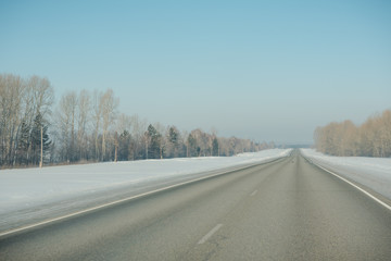 Fototapeta premium The road in winter. Asphalt road in winter. Road under the snow.