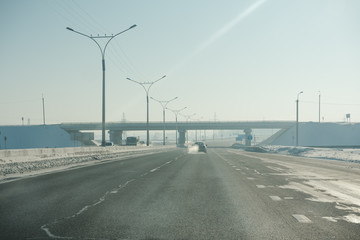 Fototapeta premium The road in winter. Asphalt road in winter. Road under the snow.