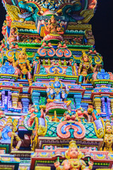 Fototapeta premium Colorful night view of indian gods sculpture at Sri Maha Mariamman Temple, also known as Maha Uma Devi temple, the public hindu temple in Silom, Bangkok, Thailand. It known as Wat Khaek Silom.