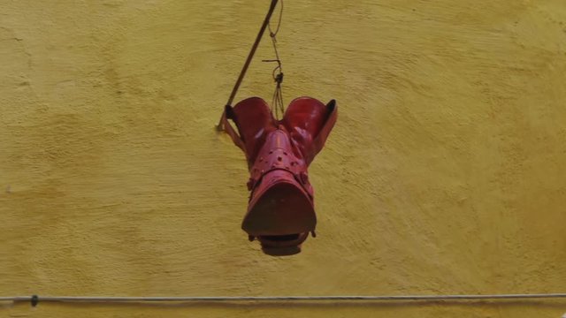 Art decor flashy red hanging shoe souvenir piece in Victoria Gozo City in Malta
(medium shot)
