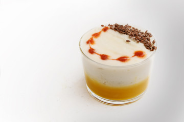 lobster bisque soup with a creamy foam topping and linen seed garnish in a glass on a light gray table, copy space, selected focus,