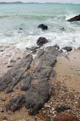 Landscapes, beautiful stones lined along the seashore And white wave bubbles And the green sea