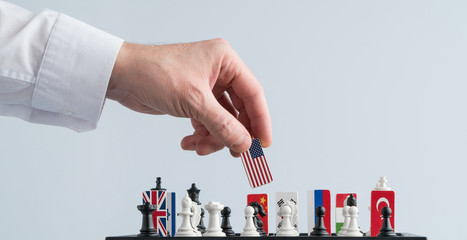 Politician's hand moves a chess piece with a flag. Conceptual photo of a political game. retaliatory move USA
