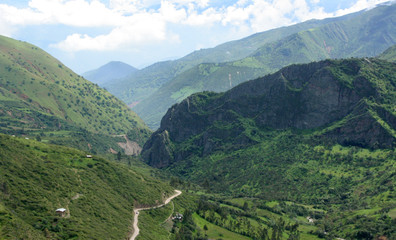 Panorama de valle verde y carretera rural entre las montañas de los andes