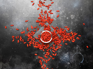 Dried red goji berries on gray background - useful and healthy food concept, flat layout with the...