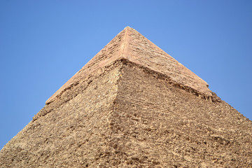 Fototapeta na wymiar Photo of the top of the pyramid of Khafre against the blue sky. Closee view. Remains of ancient veneer.