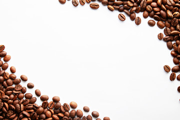 Roasted brown coffee beans scattered on white table with a lot copy space for text. Flat lay...