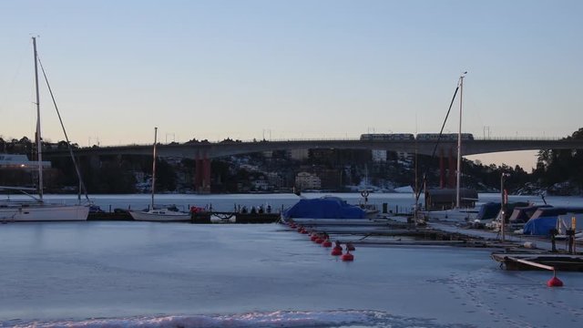 Tram crossing a bridge to Essingen a sunny morning winter over a icy lake M&auml;laren in Stockholm