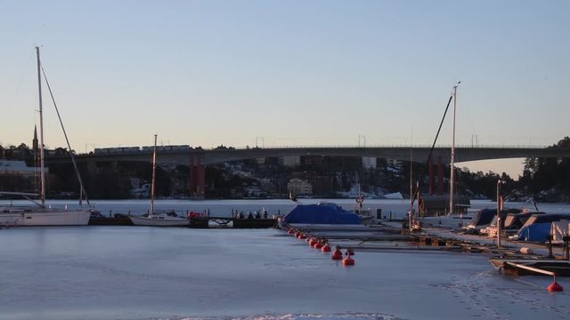 Tram crossing a bridge to Alvik a sunny morning winter over a icy lake M&auml;laren in Stockholm
