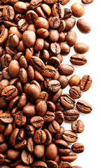 Roasted brown coffee beans scattered on white table with a lot copy space for text. Flat lay composition. Close up, top view, background.