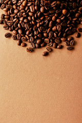 Freshly roasted coffee beans scattered on brown table with a lot copy space for text. Flat lay composition. Close up, top view, background.