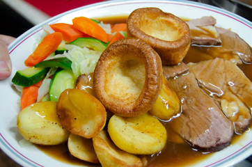 close up of plate with slow cooked beef with potatoes carots and vegetables in sauce