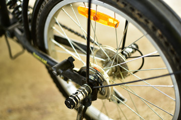 Fototapeta na wymiar Back wheel of black and orange bicycle