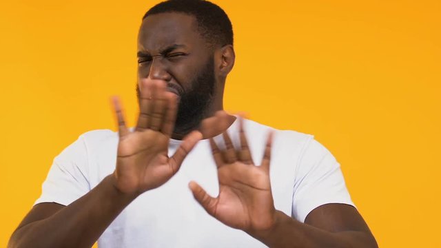 African-American showing disgust at bad smell and thumbs down, poor quality food