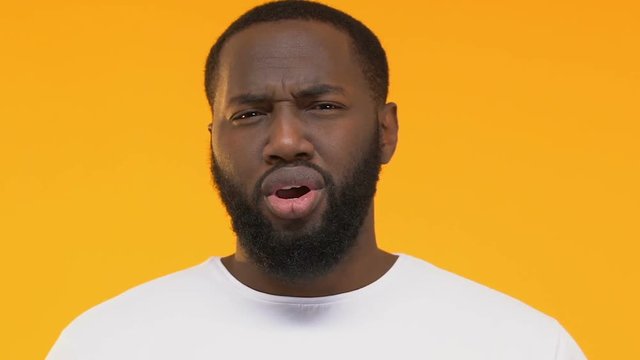 Confused Afro-American man asking question, shocking situation, face close-up