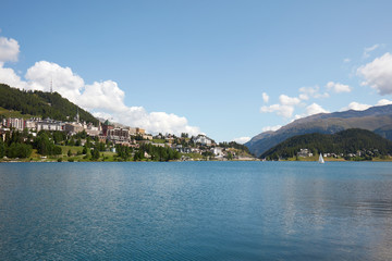 Fototapeta na wymiar Sankt Moritz town and lake with boat in a sunny summer day in Switzerland