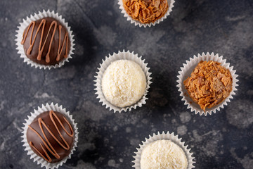 Rows of homemade chocolate sweets collection in a dark background. Top wiev.