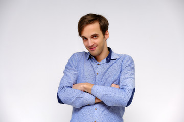 Concept studio portrait of a handsome young man isolated on a white background with different emotions in a blue shirt