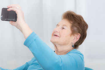 Frau macht ein Selfie von sich und freut sich darüber