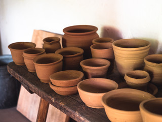 Ceramic handcraft pottery, Craftsman artist making craft, pottery, Shelves in pottery workshop full of hand crafted dishes and pots made of clay ready for glazing.