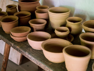 Ceramic handcraft pottery, Craftsman artist making craft, pottery, Shelves in pottery workshop full of hand crafted dishes and pots made of clay ready for glazing.