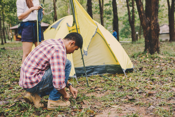 Hiking man sitting to set up a tent in national park Travel lifestyle success concept adventure