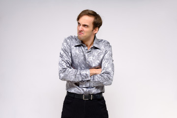 Concept studio portrait of a handsome young man isolated on a white background with different emotions in a silver-colored shirt.