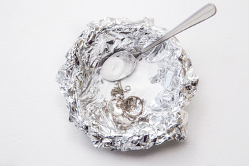 A solution of baking soda(Sodium bicarbonate) and warm water will remove the tarnish from silver...