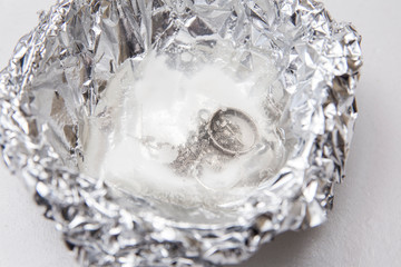A solution of baking soda(Sodium bicarbonate) and warm water will remove the tarnish from silver...