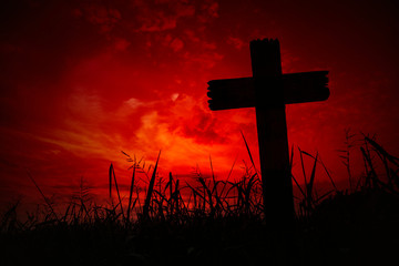 Scary background cemetery cross with dark silhouette in twilight sky, concept of horror and Halloween
