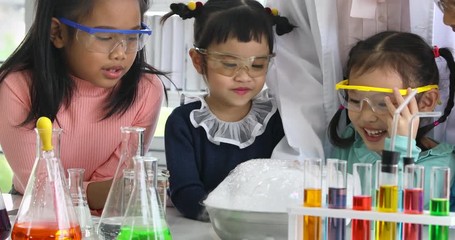 Science teacher and Asian students looking at bowl that has bubble popped, Children trying to touching bobble, teacher forbids children to don't touching it, concept for science class.