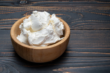 Traditional Mascarpone cheese in wooden bowl on table