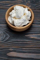 Traditional Mascarpone cheese in wooden bowl on table