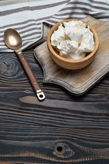 Traditional Mascarpone cheese in wooden bowl on table