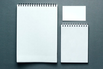 Top view of two open spiral blank notebook and blank bussines card. Mock up on gray background.