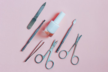 Manicure accessories on a pink background. Top view.