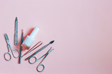 Manicure accessories on a pink background. Top view with copy space.