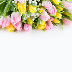 Beautiful bouquet of pink and yellow tulip on white. Close up. Top view. Copy space.
