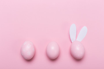 Pink easter eggs in nest on pastel color background with space. Concept